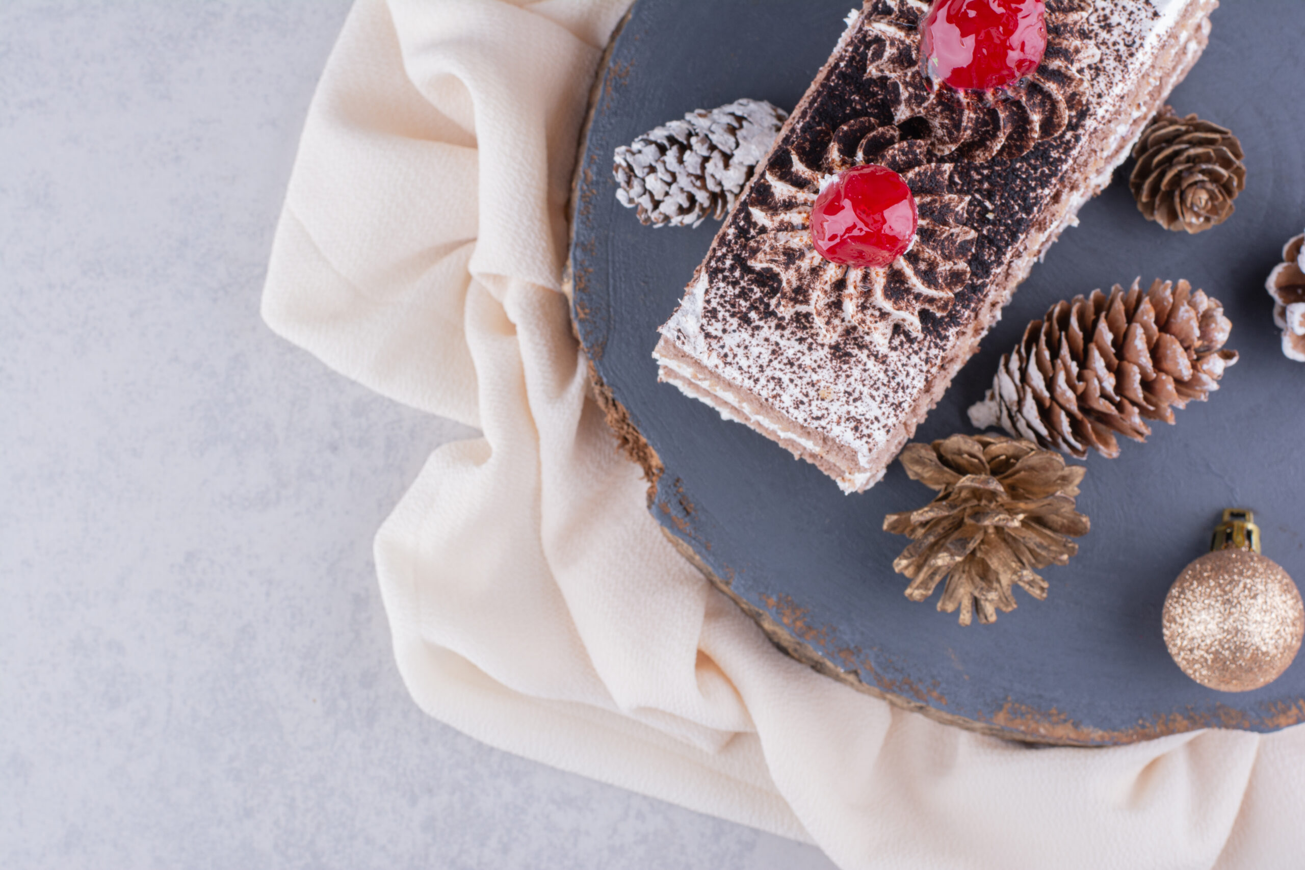 Slice of cake with Christmas ornaments on wood piece