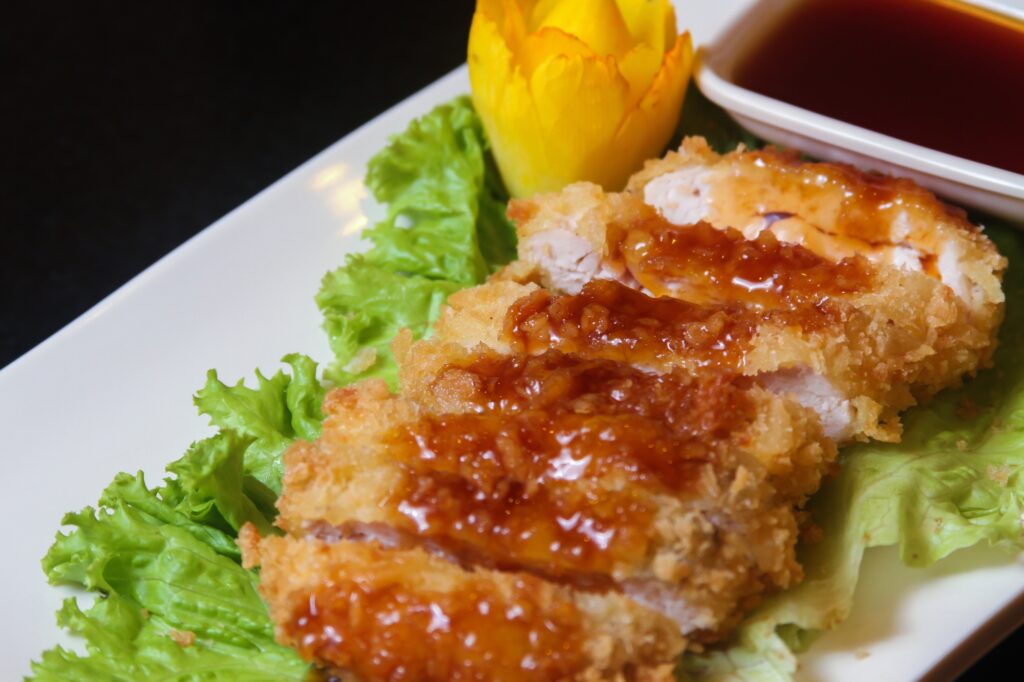 slices-fried-chicken-decorated-with-lettuce-small-bowl-sauce